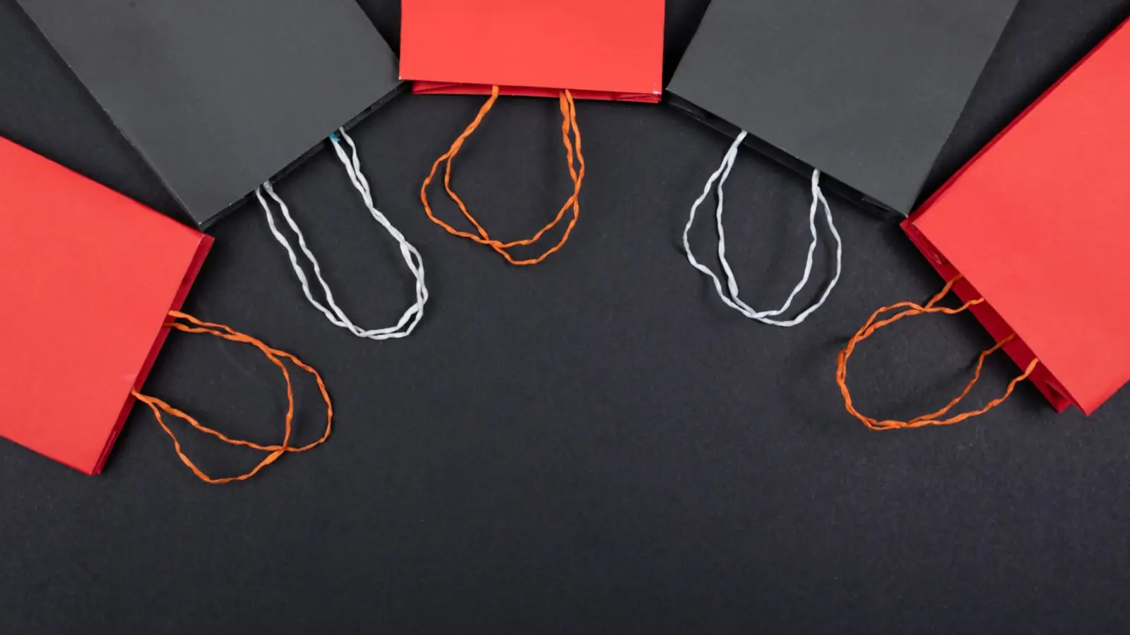 Red and black shopping bags on a dark surface