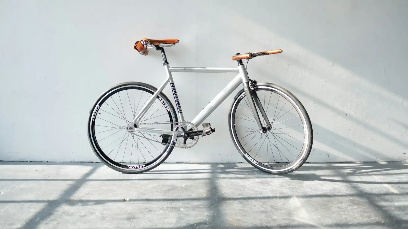 Bicycle parked against a white wall