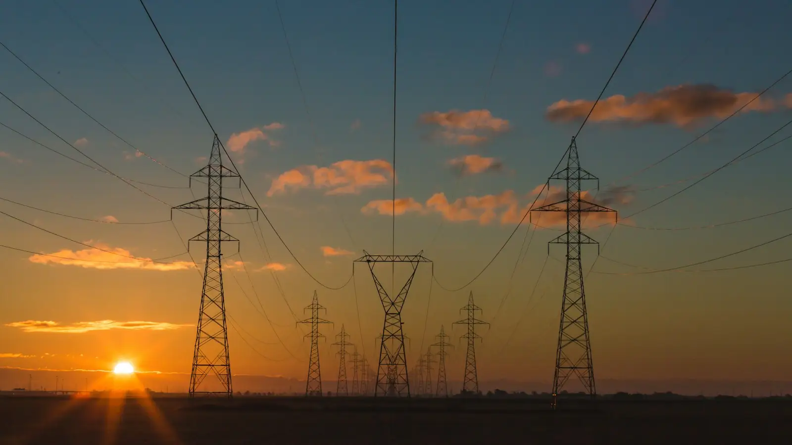Electricity pylons and power lines at sunset