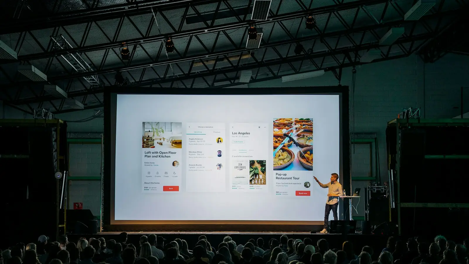 Speaker presenting on stage to a conference audience