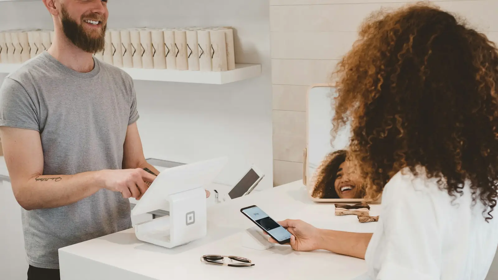 Customer paying with a smartphone at a shop counter