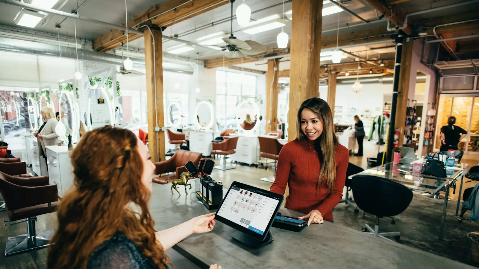 Customer paying at a tablet point-of-sale in a salon