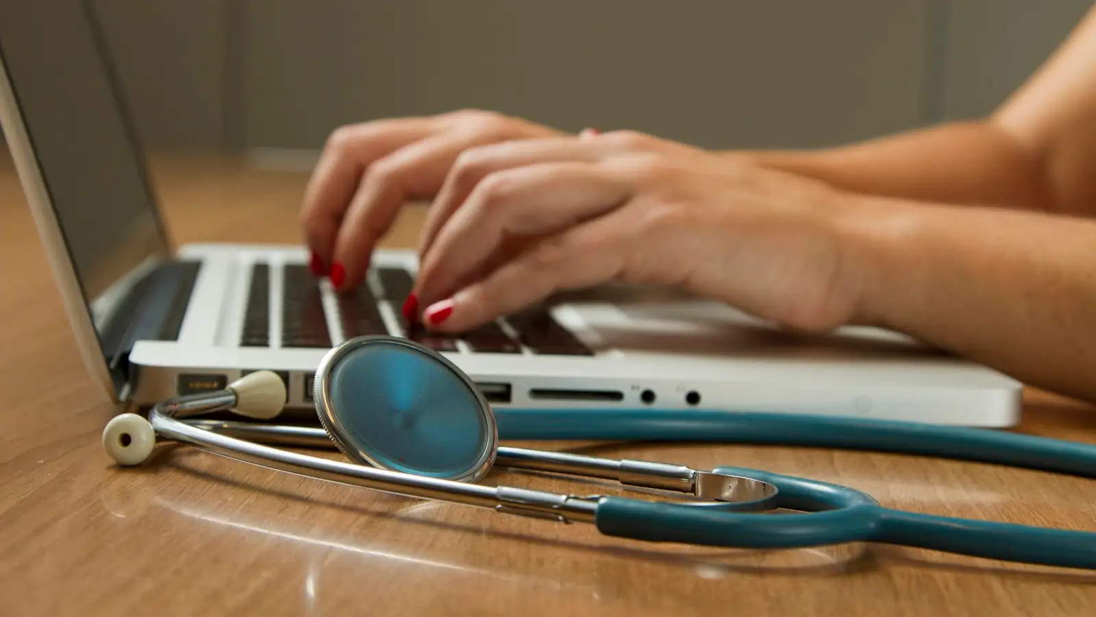 Laptop with a stethoscope resting beside it