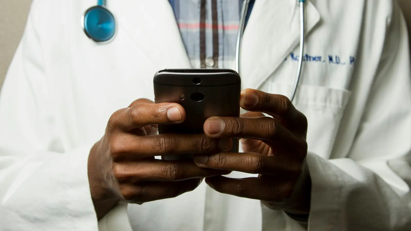 Doctor in a white coat using a smartphone