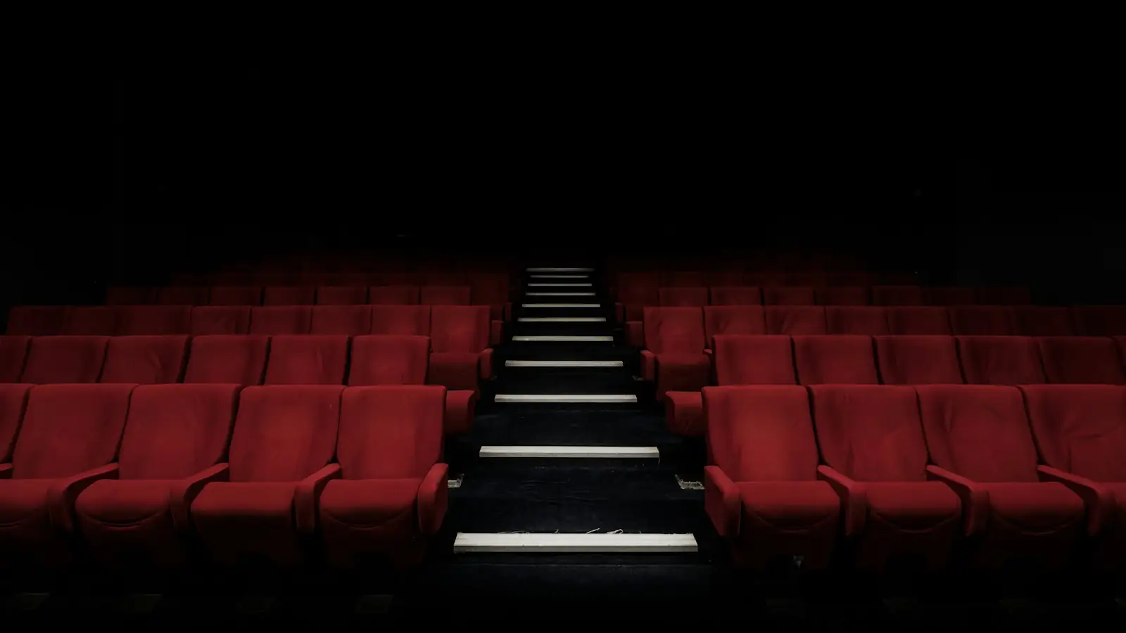 Empty cinema with rows of red seats
