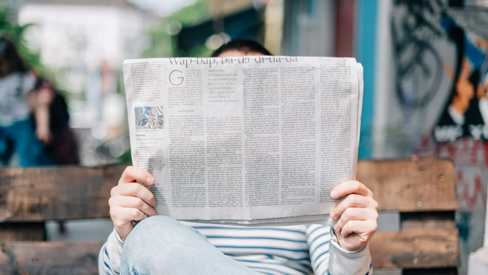 Person reading a printed newspaper