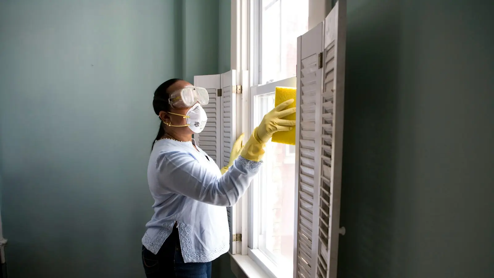 Home cleaning professional cleaning a window